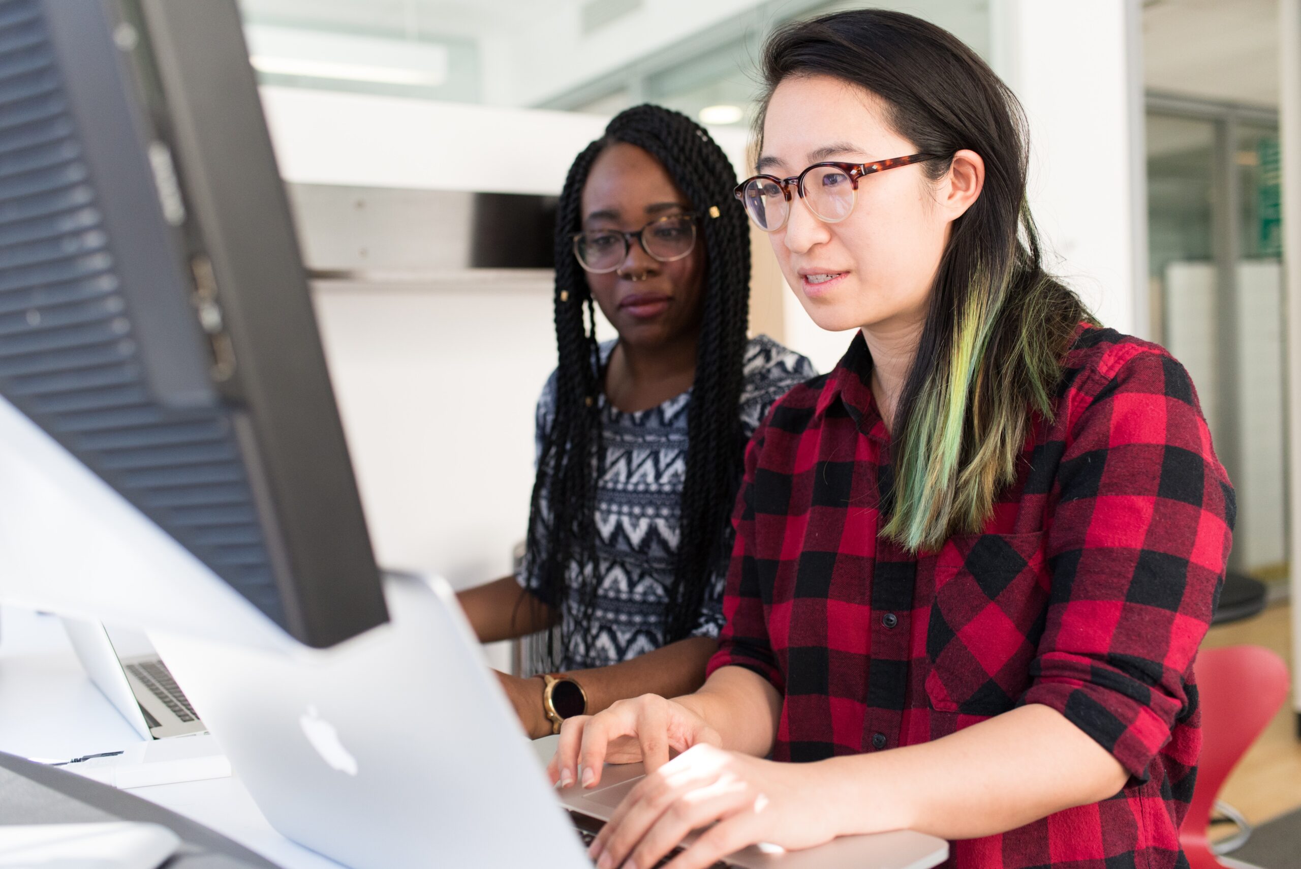 Two women working on their laptops