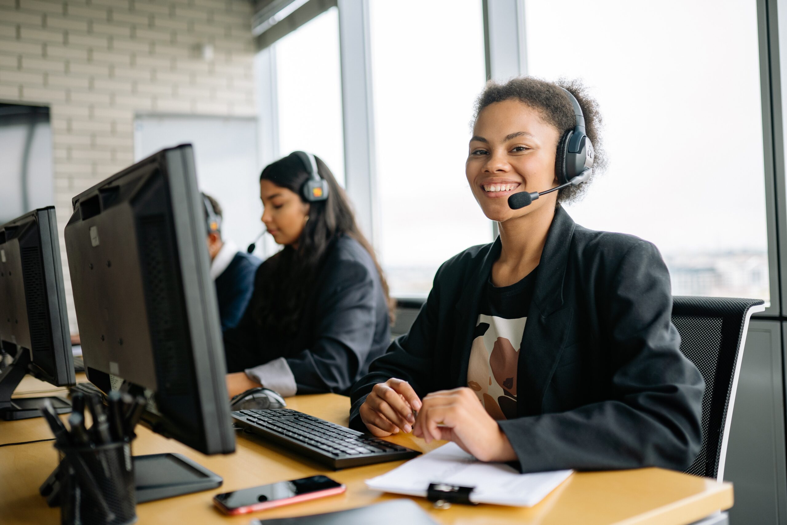 A Smiling Woman Sitting at Her Work Station